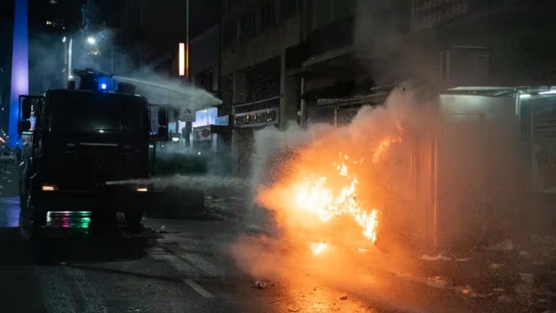 Un camión hidrante apaga un incendio en un tacho de basura.